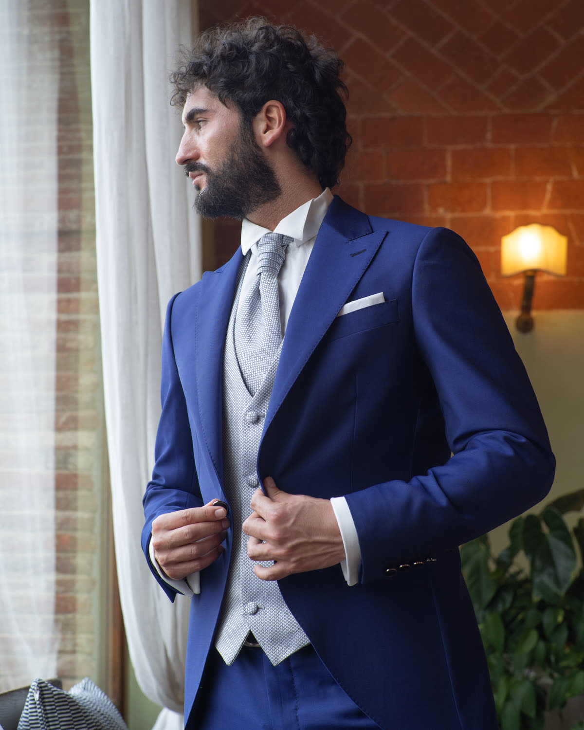 Uomo con mezzo tight blu notte e gilet grigio, ambiente interno